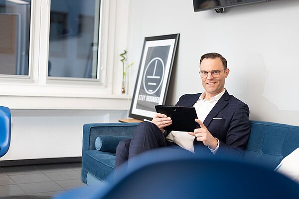 Bild von Geschäftsführer Oliver Habekost, sitzend auf einer Couch in seinem Büro.